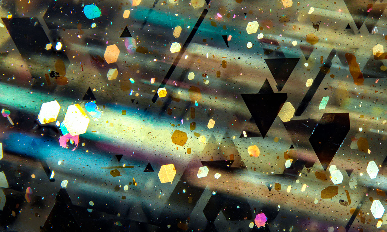 Figure 1. Parallel rays of golden, pink, and blue light were observed in this sample of rainbow lattice sunstone. Photomicrograph by Rosie Young; field of view 5.33 mm.