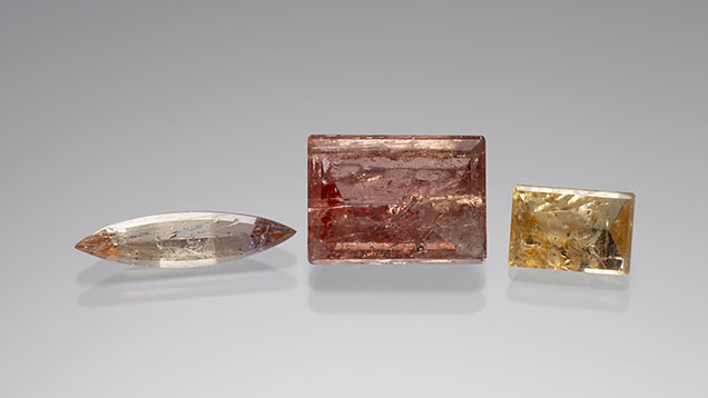 Figure 7. Imperial topaz with schiller: 1.51 ct, 7.89 ct, and 2.48 ct from left to right. Photo by Kevin Schumacher; courtesy of Jennifer Stone-Sundberg. Figure 7. Imperial topaz with schiller: 1.51 ct, 7.89 ct, and 2.48 ct from left to right. Photo by Kevin Schumacher; courtesy of Jennifer Stone-Sundberg.