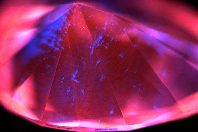 Figure 2. Representative deep-UV fluorescence image of a 2.90 ct CVD diamond from Plasmability, collected using the DiamondView. The image is dominated by red–orange fluorescence from NV0 centers, a common feature for untreated CVD laboratory-grown diamonds, along with irregular blue fluorescing dislocation bundles. No growth layers were observed, indicating that it was produced through a single uninterrupted growth cycle. Image by Madelyn Dragone.
