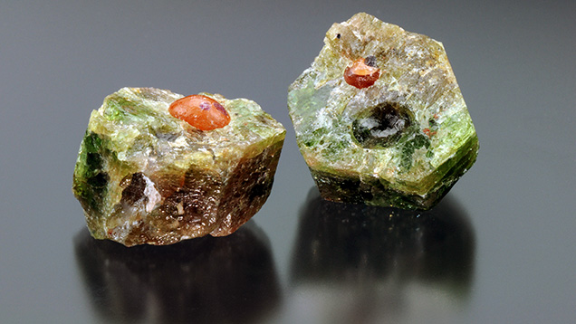 Orange spherical inclusions within the fractured fluorapatite crystal. Orange spherical inclusions within the fractured fluorapatite crystal.