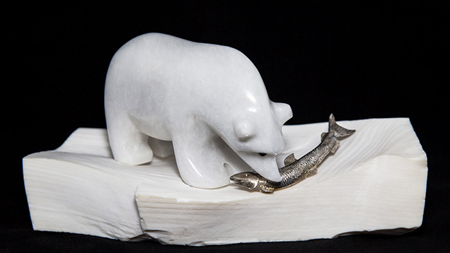 A petrified opalized wood stand supports this marble polar bear. A petrified opalized wood stand supports this marble polar bear.