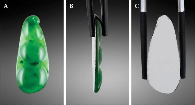 Figure 1. A: Face-up view of the 23.71 × 9.67 × 2.59 mm jade carving. B: The profile view shows the thickness of the thin film lining. C: The back of the carving shows the reflective metallic luster of the film. Photos by Diego Sanchez.
