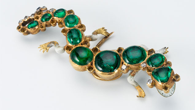 This enameled gold hat ornament in the form of a salamander is one of the Cheapside Hoard’s most iconic pieces. The enameling on the front shows an open mouth with tiny black flecks resembling teeth. The pin is decorated with cabochon emeralds from Colombia, and the tail contains table-cut diamonds. This enameled gold hat ornament in the form of a salamander is one of the Cheapside Hoard’s most iconic pieces. The enameling on the front shows an open mouth with tiny black flecks resembling teeth. The pin is decorated with cabochon emeralds from Colombia, and the tail contains table-cut diamonds.