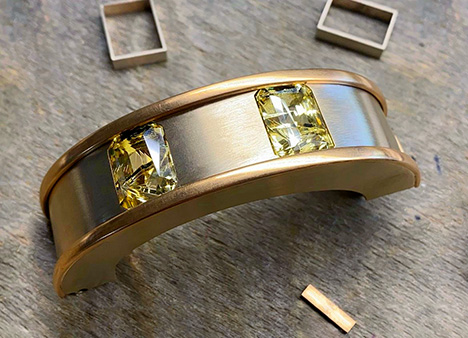 Two faceted yellow sapphires are set in a bracelet. Two faceted yellow sapphires are set in a bracelet.
