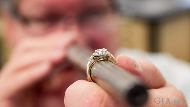 A man holds a long round metal rounded column of metal with a ring on it. The ring is in focus, his face in the background is not. A man holds a long round metal rounded column of metal with a ring on it. The ring is in focus, his face in the background is not.
