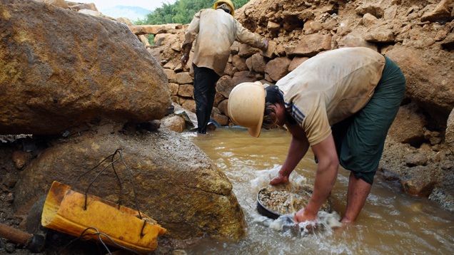 Burmese miner washes samples collected from gravel