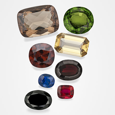 Figure 1. These examples of gem minerals that formed in magmatic environments are part of GIA’s Eduard Gübelin Collection. From top to bottom and left to right: 29.96 ct sanidine feldspar from Germany, 53.00 ct peridot from Myanmar, 11.58 ct zircon from Thailand, 20.66 ct topaz from Utah, 2.05 ct sapphire from Thailand, 18.36 ct pyrope garnet from the Czech Republic, 19.55 ct black spinel from Thailand, and 2.50 ct ruby from Thailand. Photos by Robert Weldon.