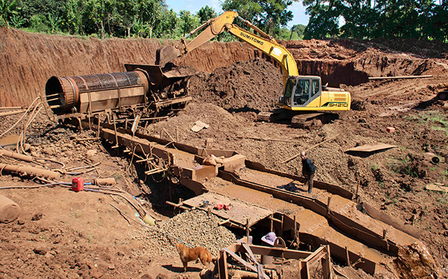 Figure 12. Mining of eluvial gem-bearing sediments from very weathered lava flows with mechanical equipment including a mechanical excavator, a rotating trammel cage to separate large rock pieces from the sediments, and a long sluice box to wash the sediments. This photo was taken in November 2020 at Khao Ploy Waen, an eroded volcano where sapphire is mined near Chanthaburi in eastern Thailand. Photo by Wim Vertriest. Figure 12. Mining of eluvial gem-bearing sediments from very weathered lava flows with mechanical equipment including a mechanical excavator, a rotating trammel cage to separate large rock pieces from the sediments, and a long sluice box to wash the sediments. This photo was taken in November 2020 at Khao Ploy Waen, an eroded volcano where sapphire is mined near Chanthaburi in eastern Thailand. Photo by Wim Vertriest.