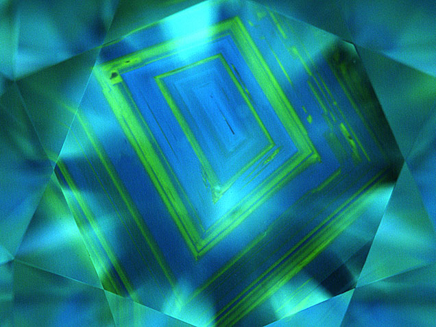 Figure 14. Natural type Ia diamonds often show a growth pattern that has been compared to the growth rings of a tree. However, it is not as common to see the alternating pattern of blue fluorescence (due to the N3 center) and green (due to H3/H4 centers) shown in this 1.83 ct K-color diamond with SI2 clarity. PL spectroscopy is very useful for confirming these centers and for detecting much weaker optical centers. Image by GIA staff.