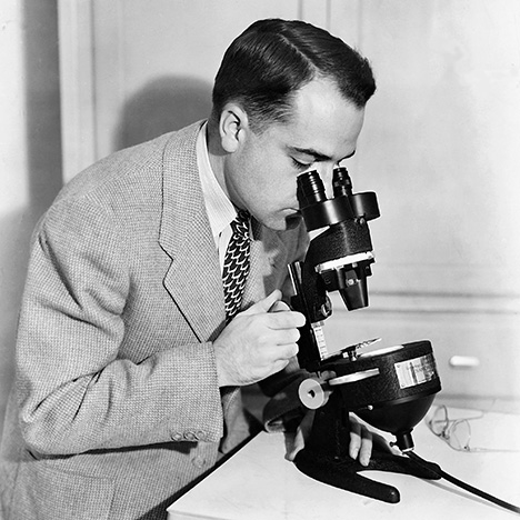 Figure 4. Richard Liddicoat using a stereomicroscope (the GIA Diamondscope) with darkfield illumination. Introduced in 1938, it provided improved viewing of inclusions and clarity features in gemstones. Figure 4. Richard Liddicoat using a stereomicroscope (the GIA Diamondscope) with darkfield illumination. Introduced in 1938, it provided improved viewing of inclusions and clarity features in gemstones.