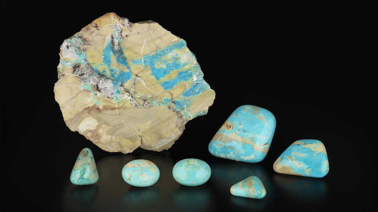 Figure 11. Stabilized turquoise cabochons (ML-01 through ML-06) weighing 4.16–37.19 ct and a 57.9 g slab from the Mona Lisa mine. Photo by Emily Lane; courtesy of Avant Mining LLC. Figure 11. Stabilized turquoise cabochons (ML-01 through ML-06) weighing 4.16–37.19 ct and a 57.9 g slab from the Mona Lisa mine. Photo by Emily Lane; courtesy of Avant Mining LLC.