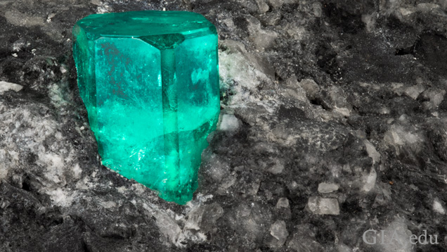 Emerald rough in dark matrix material Emerald rough in dark matrix material