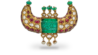 This gold pendant features a 125 carat Colombian emerald engraved in Arabic with salutations of peace. Set with diamonds, Burmese rubies, emerald beads and dangling pearls, it was made for a ruler of the Kingdom of Mysore. Mughal Era • Mysore • 18th century • emerald, ruby, diamond and pearl in 22K gold • 6 x 8.5 x 2 cm This gold pendant features a 125 carat Colombian emerald engraved in Arabic with salutations of peace. Set with diamonds, Burmese rubies, emerald beads and dangling pearls, it was made for a ruler of the Kingdom of Mysore. Mughal Era • Mysore • 18th century • emerald, ruby, diamond and pearl in 22K gold • 6 x 8.5 x 2 cm
