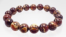 Dark brown “root amber” beads exhibit light yellow creamy swirls. Dark brown “root amber” beads exhibit light yellow creamy swirls.