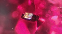 A crystal inclusion in red spinel shown in darkfield illumination (left) and fiber-optic lighting (right). Photomicrographs by Isabelle Corvin; field of view 1.78 mm. A crystal inclusion in red spinel shown in darkfield illumination (left) and fiber-optic lighting (right). Photomicrographs by Isabelle Corvin; field of view 1.78 mm.