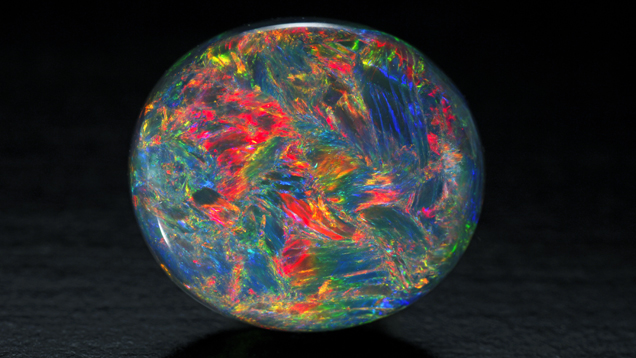 This Australian black opal oval cabochon has blue, red, yellow, orange and green colors. This Australian black opal oval cabochon has blue, red, yellow, orange and green colors.