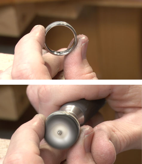 Jeweler holding a platinum band at the bench, in preparation for buffing Jeweler holding a platinum band at the bench, in preparation for buffing