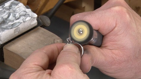 A jeweler preparing to polish a platinum ring using the yellow-treated wheel labeled “800”