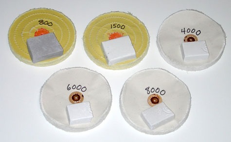 Two yellow-treated wheels labeled “800” and “1500,” and three white wheels labeled “4000,” “6000,” and “8000,”indicating the abrasive grades of the platinum polishing compounds placed on top of the wheels, Two yellow-treated wheels labeled “800” and “1500,” and three white wheels labeled “4000,” “6000,” and “8000,”indicating the abrasive grades of the platinum polishing compounds placed on top of the wheels,