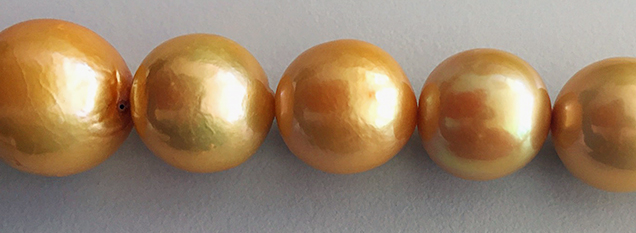 Uneven color and blemishes on low-quality cultured pearl necklace. Uneven color and blemishes on low-quality cultured pearl necklace.
