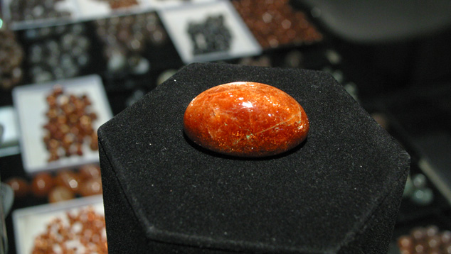 The unusual size of this 146.07-ct. oligoclase sunstone dwarfs the sunstones, moonstones, and other gems in the background. – Terri Weimer, courtesy Blue Moon Enterprise The unusual size of this 146.07-ct. oligoclase sunstone dwarfs the sunstones, moonstones, and other gems in the background. – Terri Weimer, courtesy Blue Moon Enterprise