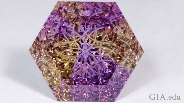 Lattice-patterned gems encase an 18K gold kaleidoscope. Lattice-patterned gems encase an 18K gold kaleidoscope.