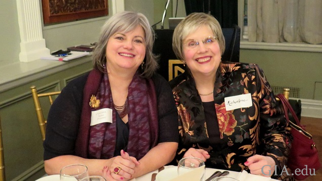 Two woman sit at table for a photo. Two woman sit at table for a photo.