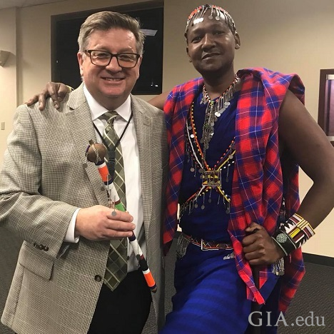A man in a suit with a man in Masai tribal clothes pose together. A man in a suit with a man in Masai tribal clothes pose together.