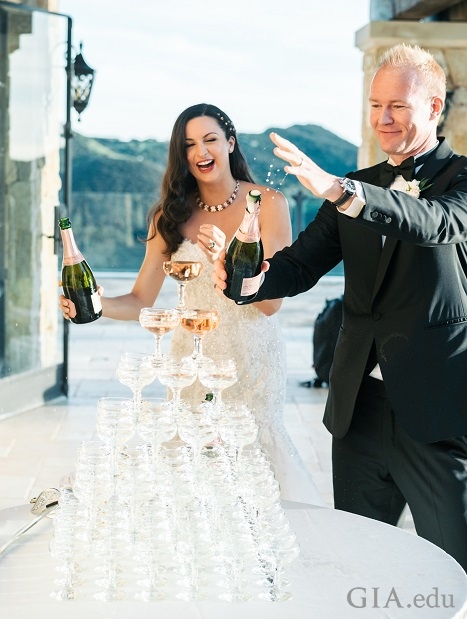 Wedding couple pours champagne over a tower of champagne glasses. Wedding couple pours champagne over a tower of champagne glasses.