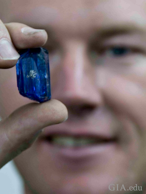 Man holds a large piece of rough tanzanite. Man holds a large piece of rough tanzanite.