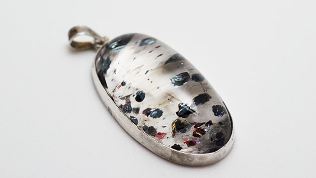 Quartz silver pendant with hematite inclusions.