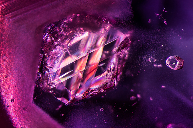Viewed between crossed polarizers, an included calcite crystal within an unheated Burmese ruby displays dramatic twinning planes. Photomicrograph by E. Billie Hughes; field of view 3.90 mm. Viewed between crossed polarizers, an included calcite crystal within an unheated Burmese ruby displays dramatic twinning planes. Photomicrograph by E. Billie Hughes; field of view 3.90 mm.