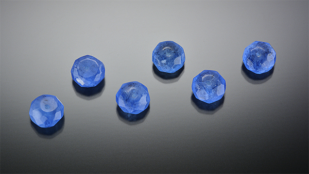 Faceted manufactured glass beads.